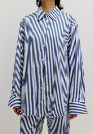 Blau-weiße gestreifte, oversized Bluse mit Knopfverschluss, spitzem Kragen und breiten Manschetten mit kontrastierenden Streifen. Weicher Stoff.