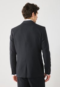 Navyblauer Anzugjackett mit taillierter Passform, mit Schlitzkragen, einer Rückenbelüftung und Manschetten mit vier Knöpfen. Glatte Textur, klassisches Design.
