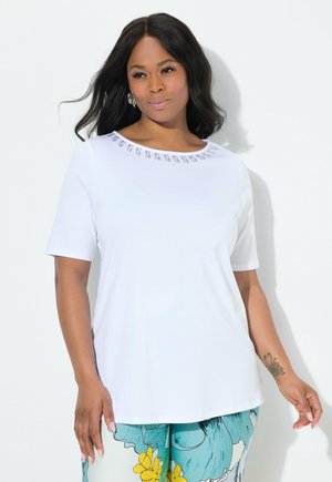 T-shirt blanc à manches courtes avec un col rond agrémenté de détails décoratifs. Le tissu semble doux et léger.