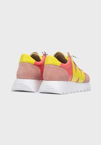 Zapatillas de ante rosa y cuero amarillo con un audaz diseño de zigzag, que presentan una suela texturizada blanca y cordones.