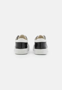 Sneakers in pelle nera con stampa a cocodrillo, suole in gomma bianca, dal design low-top e con branding sul tallone.