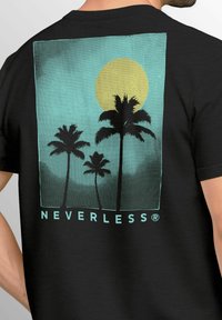 Schwarzes T-Shirt mit einem Grafikdruck von Palmen und einer gelben Sonne auf einem türkisfarbenen Hintergrund, mit dem Text "NEVERLESS" am unteren Rand.