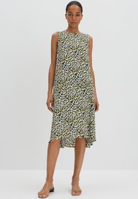 Ärmelloses Kleid im grünen, weißen und schwarzen Blumenmuster; knielang mit einem leichten High-Low-Saum; leichtes Material und lockere Passform.