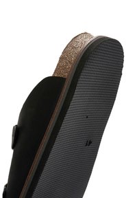 Infradito nera con sottopiede in sughero, suola in gomma nera texturizzata e materiale superiore liscio. Presenta due cinghie regolabili con fibbie in metallo.