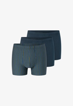 Tres pares de bóxers para hombre, dos de color azul oscuro sólido y uno azul con rayas verticales amarillas y grises, dispuestos en una pila escalonada.