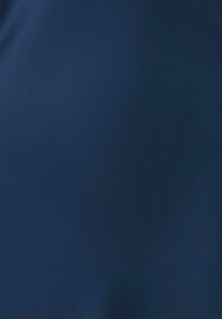 Texture de tissu bleu foncé uni avec des plis subtils et une finition mate douce.