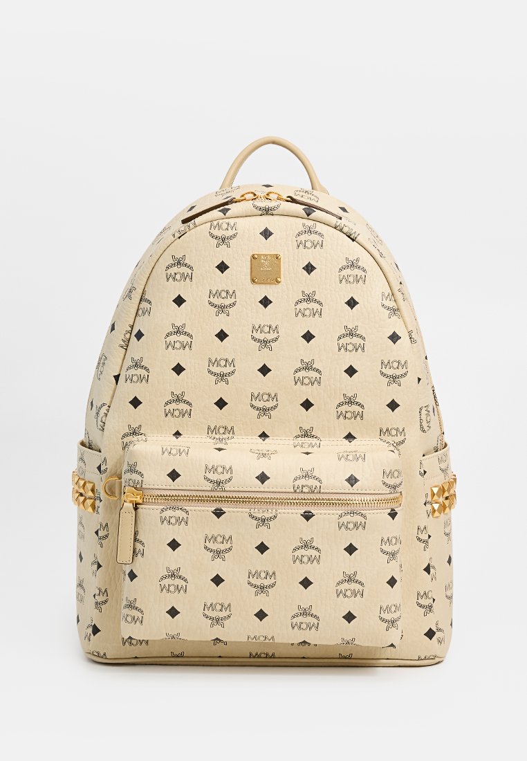 Beige Rucksack mit schwarzem Logo-Muster, glatter Textur, goldenen Beschlägen und einer vorderseitigen Reißverschlusstasche, runder Form.