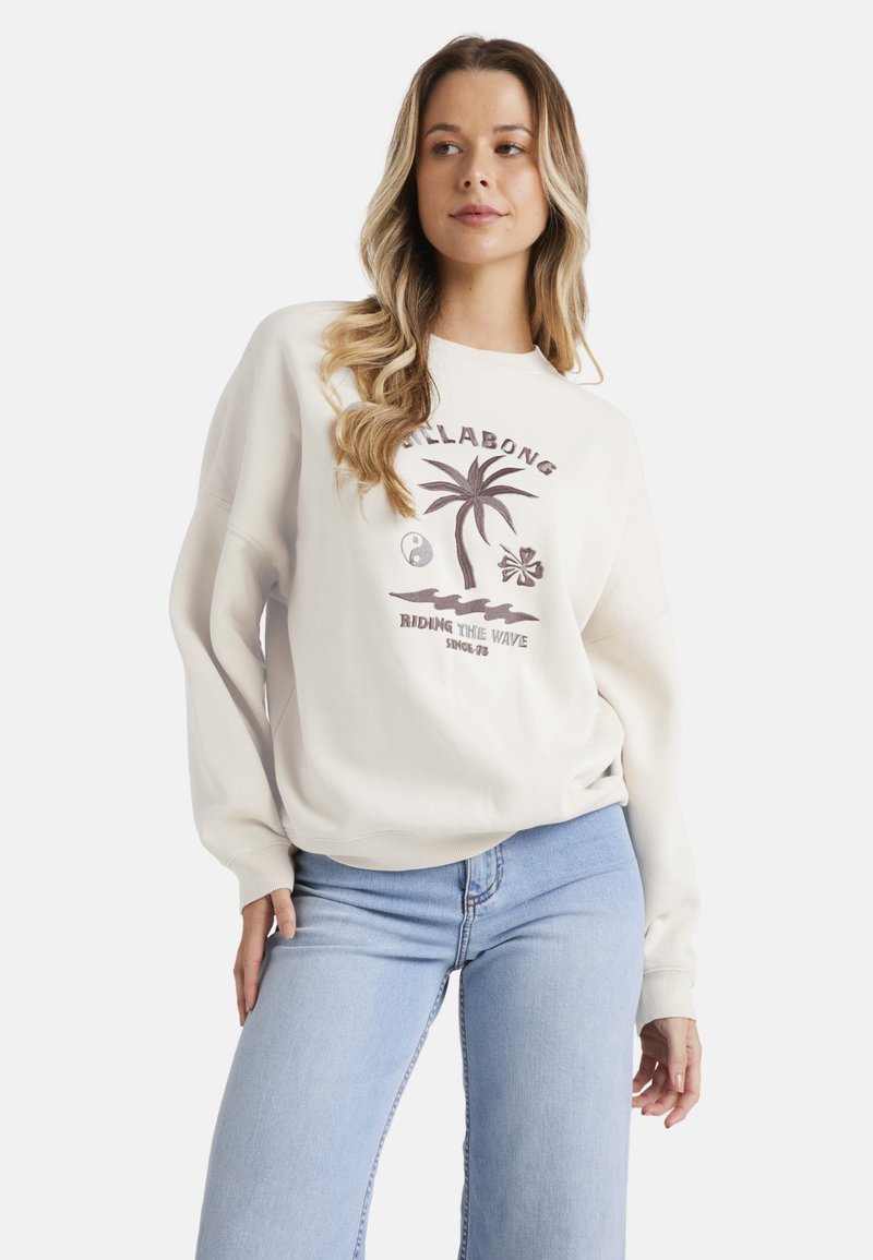Sudadera crema con cuello redondo, que presenta un gráfico de palmera y yin-yang. Material suave, corte relajado, puños y dobladillo acanalados.