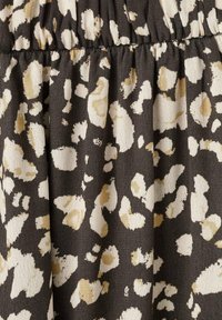 Črna tkanina z abstraktnimi bež in krem leopardjimi lisami, s teksturirano površino in nabranim detajlom v pasu.