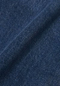 Denim w głębokich odcieniach niebieskiego, o gładkiej fakturze i subtelnych wariacjach kolorystycznych. Splot ukazuje klasyczny wzór końcówki.