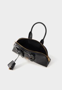 Svart skinnveske med høyglansfinish, med gullglidelås og detaljer, doble håndtak og en avtagbar merkelapp. Innvendig er det romslig med kortlommer.