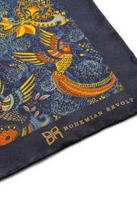 Silkkihuivi, jossa on tummansininen tausta. Esteettiset kukka- ja lintukuvastot keltaisena, oranssina ja sinisenä. Brändilogo: Bohemian Revolt.
