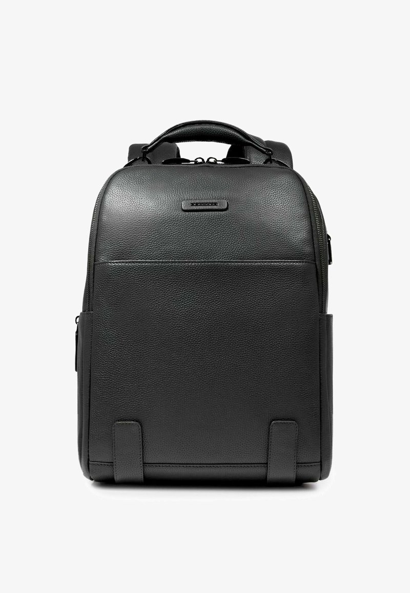 Mochila de cuero negro con textura lisa, forma rectangular, asa superior, correas ajustables y diseño minimalista. Incluye bolsillos laterales.