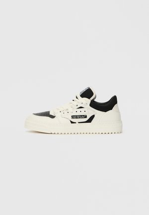Zemas Off-White kedas baltā un melnā krāsā ar auklām priekšā, caurlaižamu purngali, un zīmola uzlīmi sānu paneļī.