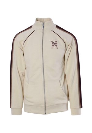 Giacca beige con zip, colletto alto, strisce laterali marroni, tasche frontali e logo sul petto sinistro. Tessuto morbido, vestibilità comoda.