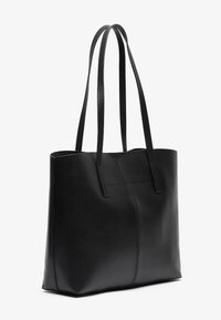 Sac fourre-tout en cuir noir avec deux longues poignées, forme rectangulaire, texture lisse et un détail de couture subtil sur le devant.