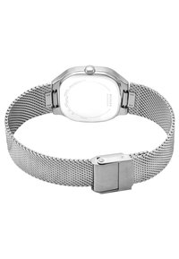 Stříbrné hodinky na síťovém pásku s obdélníkovým pouzdrem, leštěným povrchem a minimalistickým designem. Disponují nerezovým zapínáním a hladkým zadním víkem.