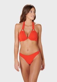 Röd bikini-set som har ett halterneck-bh med cirkulär hårdvara och mjukt, texturerat tyg; matchande lågrisk bikiniunderdel.