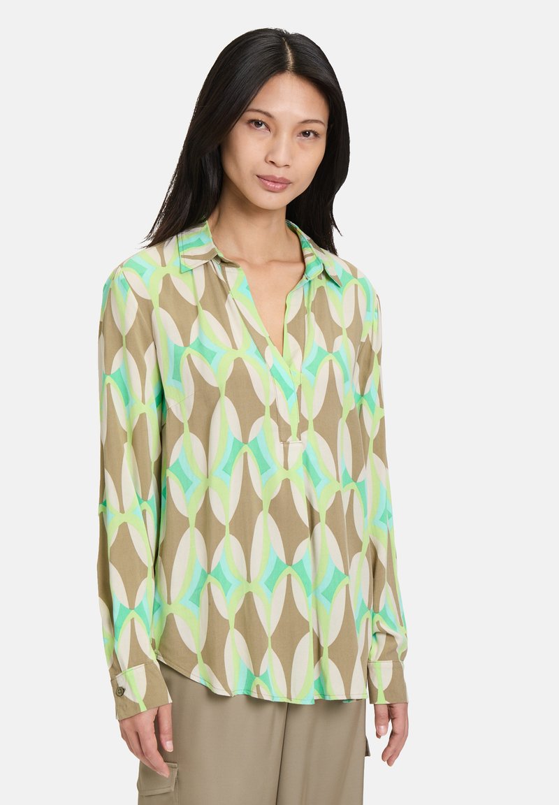 Camicia a maniche lunghe con motivo geometrico in marrone, verde e bianco. Design con colletto, patta e dettagli con polsini abbottonati. Tessuto morbido.