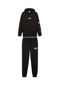 Sudadera negra con bolsillo frontal y cordón, con logotipos en las mangas, combinada con pantalones de chándal negros a juego, con cintura elástica y logotipo.