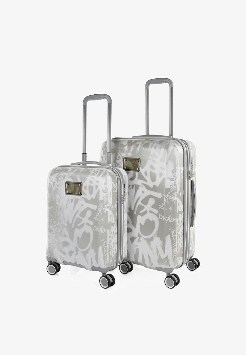 Juego de maletas de carcasa dura en gris con estampado estilo grafiti blanco. Cuenta con asas retráctiles y cuatro ruedas para mayor movilidad.