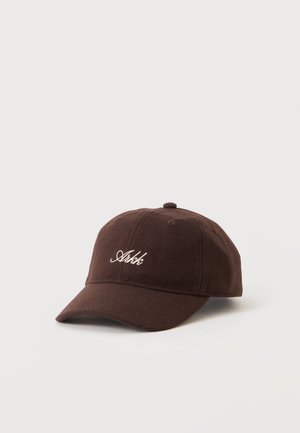 Casquette de baseball marron foncé avec une visière incurvée et un texte brodé en cursive blanche au centre avant sur fond clair uni.