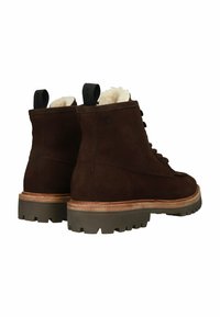 Rudi suede auliniai batai su tekstūruota paviršiumi, balta pamušalu ir storu guminio pado pagrindu. Yra traukimo kilpelė ir raišteliai priekyje.