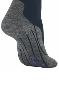 Zbliżenie skarpety z ciemnoniebieskim i szarym wzorem, z teksturowanymi desenami, podkreślającymi piętę i palce dla lepszej przyczepności.