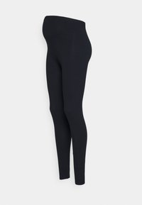 Leggings extensibles noirs conçus pour la maternité, avec une taille haute et une texture lisse, présentant une silhouette ajustée qui se resserre jusqu'à la cheville.
