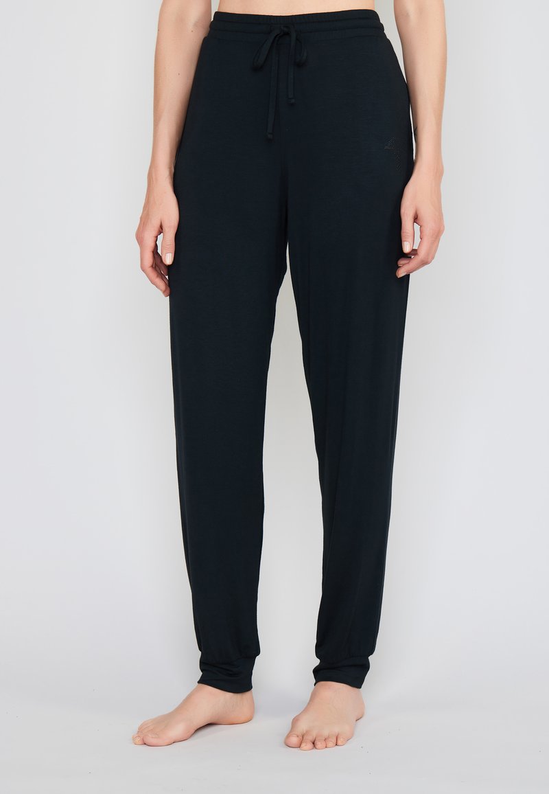 Tmavé, lehké kalhoty na volný čas vyrobené z měkké látky. Obsahují elastický pas se šňůrkou a přiléhavé manžety na kotnících.