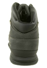 Schwarze Leder- und Wildleder-Low-Top-Stiefel mit gepolstertem Kragen, strukturiertem Obermaterial und kontrastierenden Nähten an den Seiten.