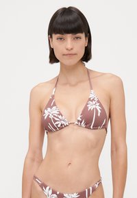 Set di bikini marrone con motivo a foglie di palma bianche; presenta coppe triangolari e lacci sottili al collo e sulla schiena; tessuto morbido e testurizzato.
