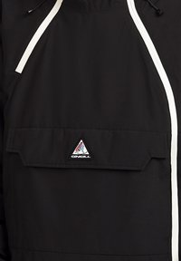 Giacca nera O'Neill con linee bianche in evidenza, una tasca frontale con patta e un patch logo triangolare sulla tasca. Realizzata in tessuto liscio.