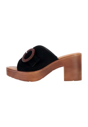 Sandale-slide en suede noir avec un accent rond marron, un talon en bois et un design à bout ouvert. Texture subtile, forme courbée et semelle robuste.