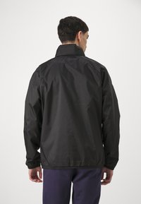 Black, lightweight jacket with a standing collar and elastic cuffs, featuring a smooth texture and a simple design. Back view shown.