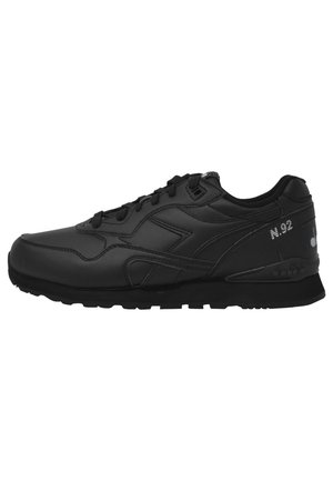 Baskets basses noires avec lacets à l’avant, semelle texturée et détails de la marque incluant « N.92 » sur le côté.