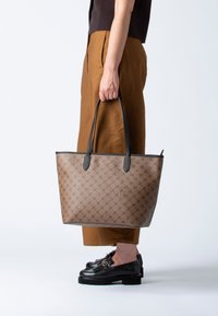 Borsa a tracolla marrone con motivo, manici e rifiniture in pelle nera. Forma rettangolare con un sottile dettaglio del logo sul davanti.