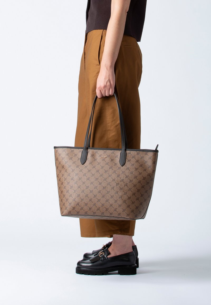 Borsa a tracolla marrone con motivo, manici e rifiniture in pelle nera. Forma rettangolare con un sottile dettaglio del logo sul davanti.