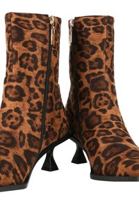 Botines de charol con estampado de leopardo, hechos de un tejido suave y con detalles de cremallera negra, que cuentan con punta afilada y tacones de gatito.