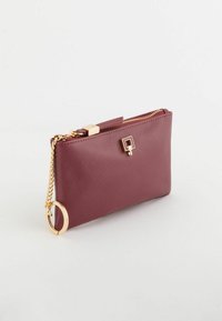 Viininpunainen tekonahkainen lompakko, jossa on tekstuuri, kullanvärinen vetoketju, neliölogo ja ketju, jossa on sormuskiinnitys. Kompakti suorakulmainen muoto.
