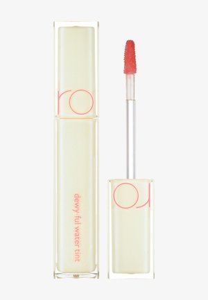Clear rectangular container with pink accents; applicator wand with soft tip; liquid tint appears in a light peachy shade.