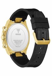 Et guld- og sort armbåndsur, der viser bagsiden med et hus i rustfrit stål, vandtætheden og et sort gummirem.