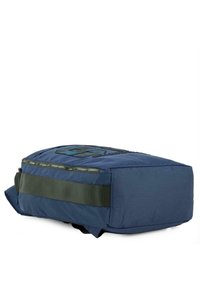 Bolsa de tela azul marino con forma rectangular, que cuenta con una correa verde, detalles de cremallera y un logotipo en relieve en la superficie.