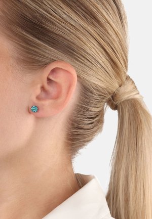 Pendientes de estudio en tono teal hechos de piedra preciosa, con forma redonda y superficie lisa, fijados de forma segura en un respaldar metálico.