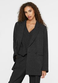 Dark gray tailored suit jacket featuring a notched collar, single button closure, and textured fabric, layered over a matching vest.