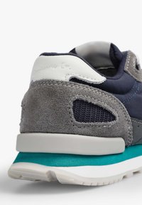 Zapatillas con una parte superior en azul marino, acentos de ante gris y una tapa de talón blanca, con una media suela en azul verdoso y detalles de malla.