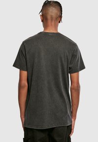 Sort, kortærmet t-shirt med en falmet look, rund halsudskæring og en let løs pasform; synlige syninger på ærmerne og kanten.