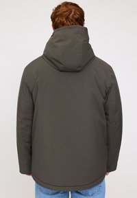 Dark green padded jacket with a hood, featuring a smooth texture and seamless design. Plain back with rounded hem and no visible hardware.