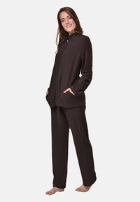 Brown, soft fabric lounge set featuring a zip-up jacket with side pockets and loose-fitting pants, designed for comfort and ease of movement.
