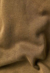 Tejido de algodón suavemente verde oliva, con una textura lisa y un ligero estiramiento, presentado en una posición arrugada y drapeada.